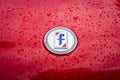 Emblem of the Italian carrozzeria Pininfarina on the Fiat 124 Sport Spider in raindrops.