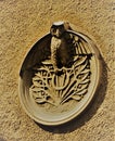 Embleme on the wall of old house and fir tree in botanical garden in summer Helsinki, Finland