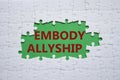 Embody Allyship symbol. Concept word Embody Allyship on white puzzle. Beautiful green background. Business and Embody Allyship