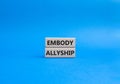 Embody Allyship symbol. Concept word Embody Allyship on wooden blocks. Beautiful blue background. Business and Embody Allyship