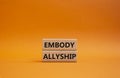 Embody Allyship symbol. Concept word Embody Allyship on wooden blocks. Beautiful orange background. Business and Embody Allyship