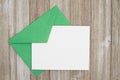 An embossed blank white card with green envelope on weathered wood Royalty Free Stock Photo