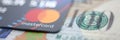 Embossed chipped mastercard credit card and hundred dollar bank notes closeup