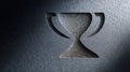 Embossed trophy symbol on textured dark surface for a congratulations card with lighting Royalty Free Stock Photo