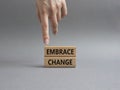 Embrace change symbol. Concept word Embrace change on wooden blocks. Beautiful greybackground. Businessman hand. Business and Royalty Free Stock Photo