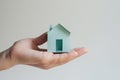 affordable housing dream: hand holding paper house on light background, Generative AI Royalty Free Stock Photo