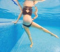 Embracing aquatic fitness, a pregnant woman demonstrates strength and serenity in underwater aerobics, creating a serene