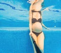 Embracing aquatic fitness, a pregnant woman demonstrates strength and serenity in underwater aerobics, creating a serene