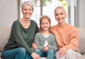 Embracing family time. Portrait of a mature woman bonding with her daughter and granddaughter on the sofa at home. Royalty Free Stock Photo