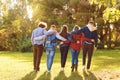 Embracing friends walking together in park Royalty Free Stock Photo