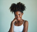 Embracing her natural beauty. Studio shot of a beautiful, fresh faced young woman posing against a green background.