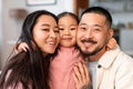 Portrait Of Happy Asian Parents Hugging Little Daughter At Home Royalty Free Stock Photo