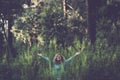 Embracing outdoor and love nature concept with happy beautiful woman in the middle of a forest trees wood in total happiness and