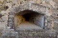 An embrasure for shooting in the thick wall of an old fortress or castle Royalty Free Stock Photo