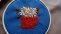 Embroidered cup with chamomile flowers in a hoop
