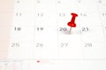 Embroidered red pins on a calendar on the 20th