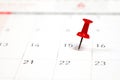 Embroidered red pins on a calendar on the 15th