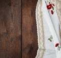 Embroidered white dishcloth with lace on a brown wooden background Royalty Free Stock Photo
