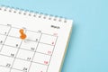 The Embroidered wooden pins on a blank calendar on the Friday 11th, March with selective focus on blue background