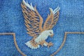 embroidery with colored threads in the form of eagle on a blue cotton fabric Royalty Free Stock Photo