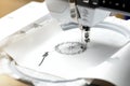 embroidery with embroidery machine - dandilon on white leatherette - view on embroidery process