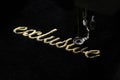 embroidery of gold lettering & x22;exclusive& x22; on black velvety fabric with embroidery machine Royalty Free Stock Photo