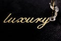 embroidery of gold lettering & x22;luxury& x22; on black velvety fabric Royalty Free Stock Photo