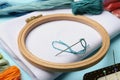 Embroidery hoop, different threads, fabric and needles on light blue background, closeup Royalty Free Stock Photo
