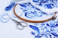 Embroidery hoop with fabric, sewing needle and thread. Handmade Embroidery pattern of blue flowers on a white background Royalty Free Stock Photo