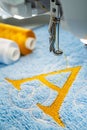 Embroidery machine and alphabet logo on towel Royalty Free Stock Photo