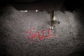 embroidery of red lettering SALE on soft grey fabric with embroidery machine - top view with moving needle bar