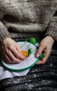 Embroidery in woman hands, female doing flower pattern embroidery on grandma natural clothes