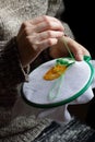 Embroidery in woman hands, female doing flower pattern embroidery on grandma natural clothes