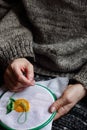 Embroidery in woman hands, female doing flower pattern embroidery on grandma natural clothes