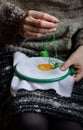 Embroidery in woman hands, female doing flower pattern embroidery on grandma natural clothes