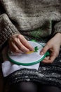 Embroidery in woman hands, female doing flower pattern embroidery on grandma natural clothes