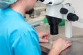 Embryologist or lab technician adjusting needle to fertilize a human egg under the microscope. Doctor adding sperm to egg using mi