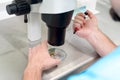 Embryologist or lab technician adjusting needle to fertilize a human egg under the microscope. Doctor adding sperm to egg using mi