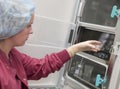 Embryologist putting sample into incubator