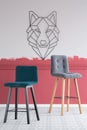 Green and grey velvet bar stools in empty interior with burgundy and white ombre wall