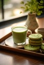 An emerald green matcha latte sits on a wooden tray with a small dish of matcha cookies. Royalty Free Stock Photo