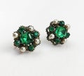 Emerald green rhinestone and pearl vintage earrings on beige background, statement retro jewelry for women Royalty Free Stock Photo