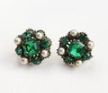 Emerald green rhinestone vintage earrings on beige background, statement retro jewelry for women Royalty Free Stock Photo