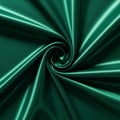 Emerald green satin fabric with a smooth, glossy texture forms a swirling pattern. The Royalty Free Stock Photo