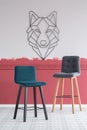 Emerald and grey velvet bar stools in empty interior with burgundy and white ombre wall