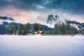 Emerald Lake with wooden lodge glowing in snowy pine forest and rocky mountains on winter at Yoho national park Royalty Free Stock Photo