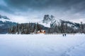 Emerald Lake with wooden lodge glowing in snowy pine forest and rocky mountains on winter at Yoho national park Royalty Free Stock Photo