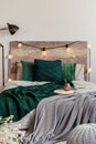 Emerald green pillows and blanket on wooden king size bed with grey bedding Royalty Free Stock Photo