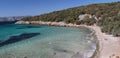 Random lonely tourist sunbathing on a gravel beach in a wild rocky cove near Bodrum in Turkey. Royalty Free Stock Photo