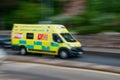 emergency ambulance with motion blur speeds along a public road with blue lights Royalty Free Stock Photo